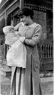 Molly with one of her children in front of the family home.